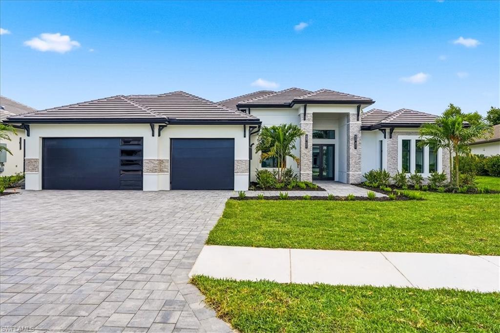 14318 Charthouse Circle Naples, FL 34114 - Photo 1 of 36 a front view of a house with a yard and garage