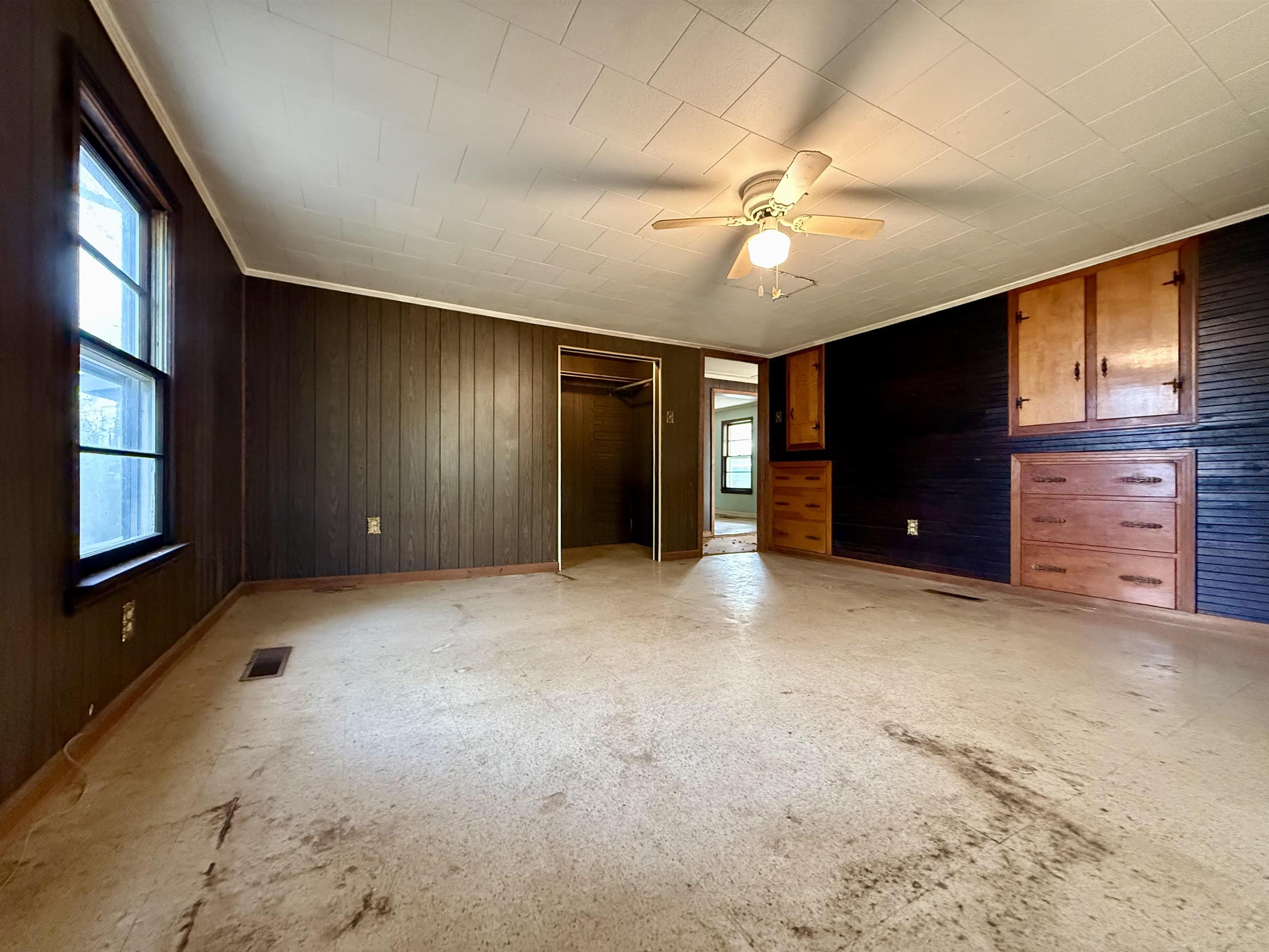 845 Needham Road Drummonds, TN 38023 - Photo 10 of 22 Unfurnished bedroom featuring wooden walls, a closet, and a ceiling fan