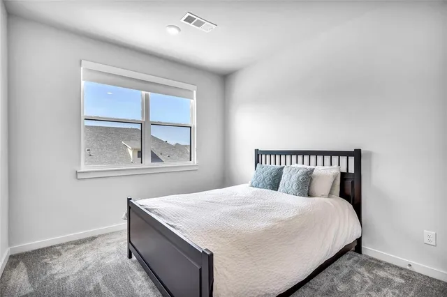 a bedroom with a large bed and a window