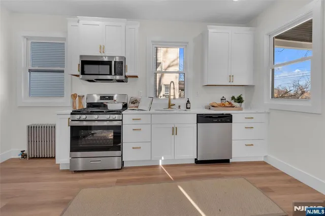 a kitchen with white cabinets and stainless steel appliances