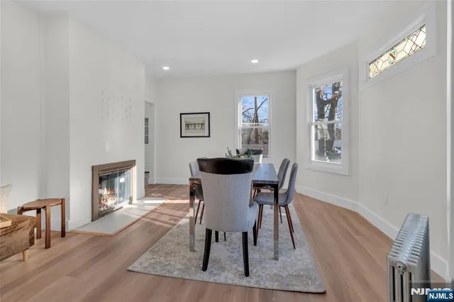 a view of a dining room with furniture a fireplace and wooden floor