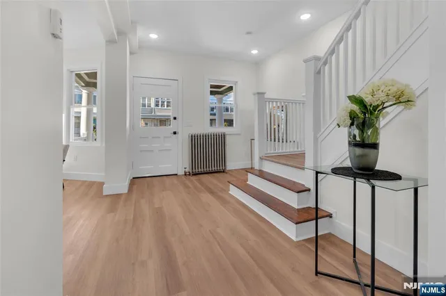 a view of a hallway with wooden floor and staircase