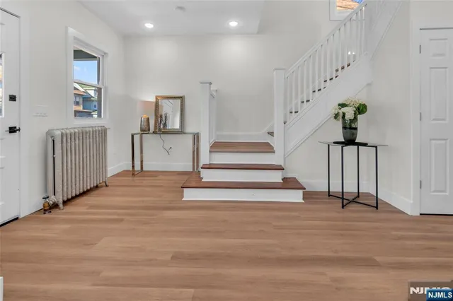 a view of entryway and hall with wooden floor