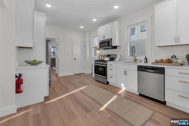 a kitchen with stainless steel appliances a sink stove and cabinets