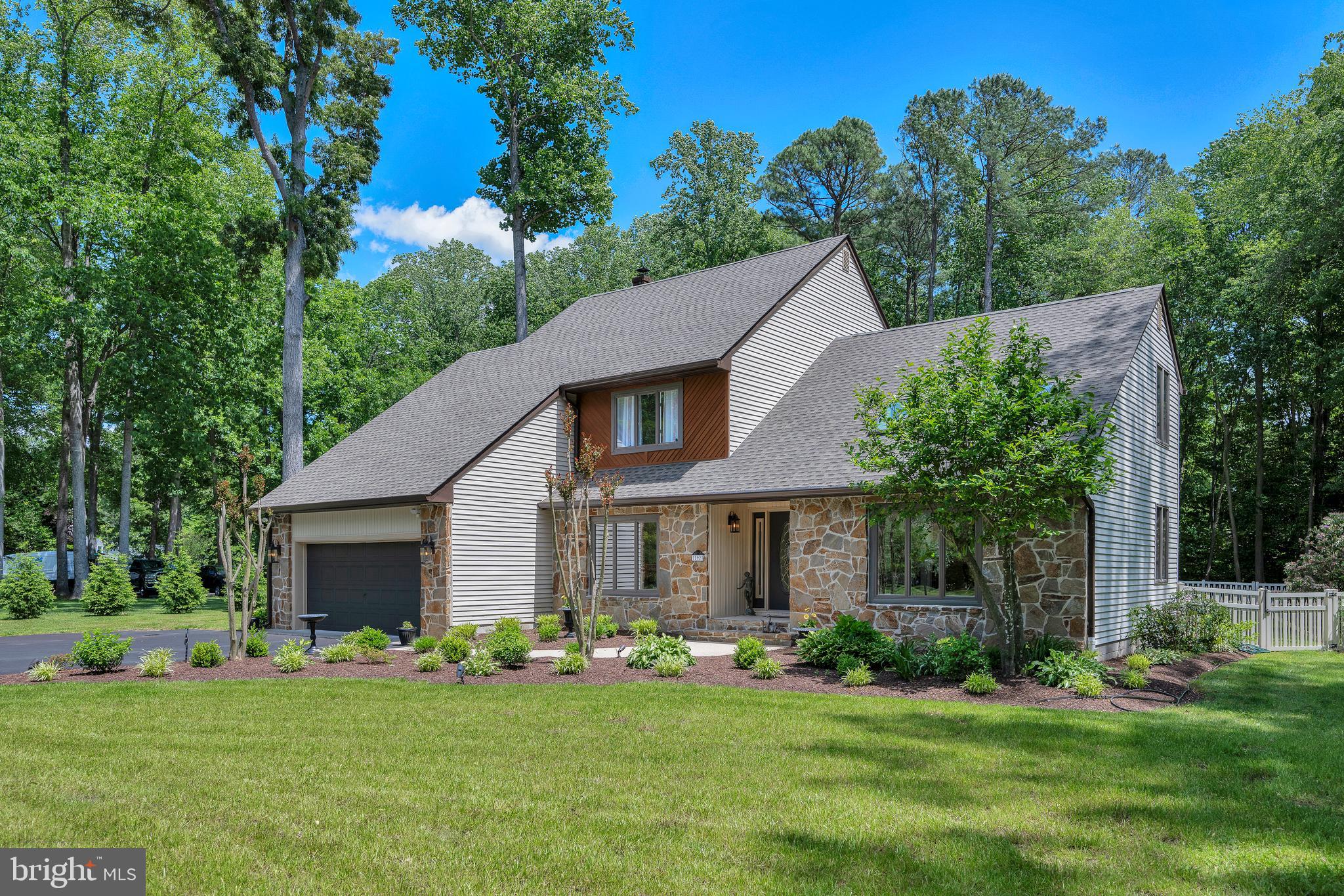 292 Pond Road Millsboro, DE 19966 - Photo 52 of 66 a front view of a house with a garden and trees