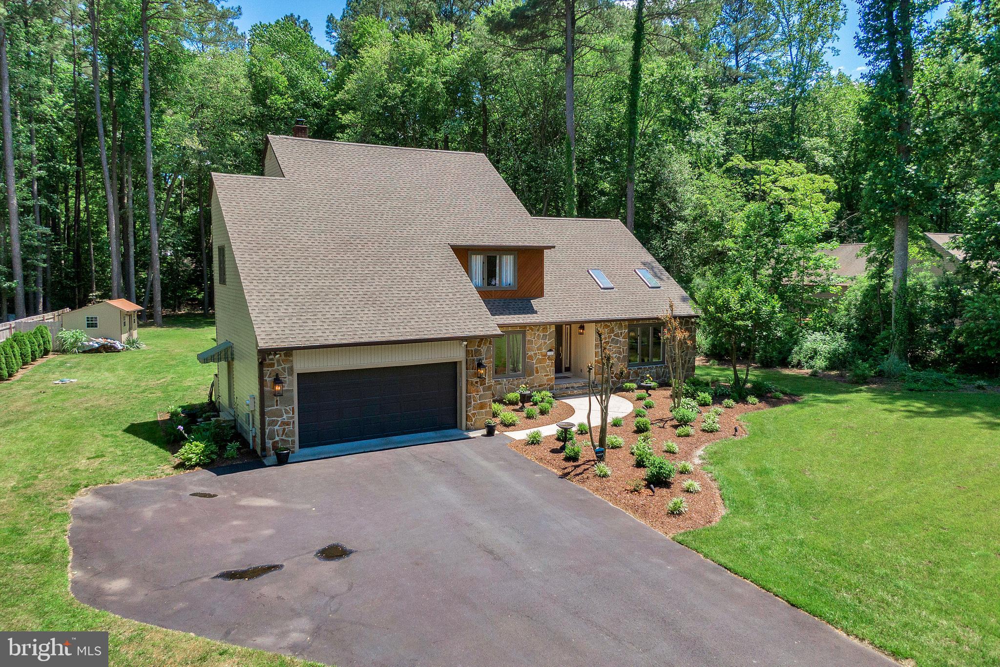 292 Pond Road Millsboro, DE 19966 - Photo 54 of 66 a front view of a house with a garden and patio