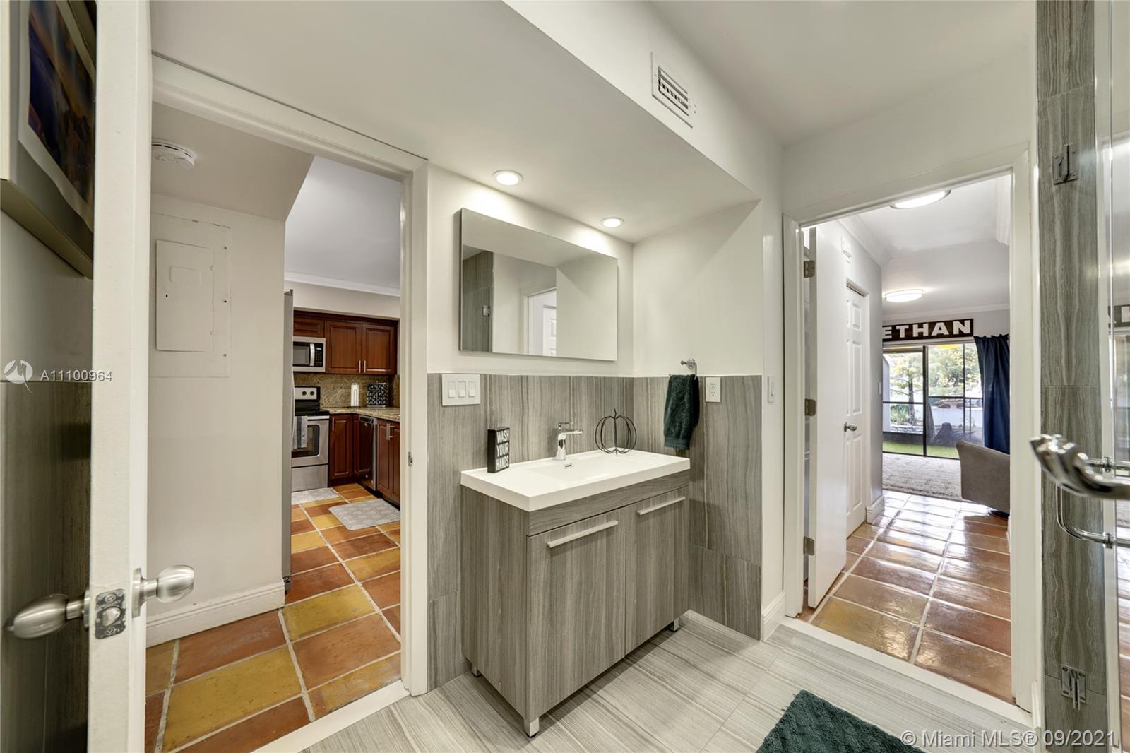 16409 Bridge End Road Miami Lakes, FL 33014 - Photo 22 of 30 a kitchen with kitchen island a sink appliances and cabinets