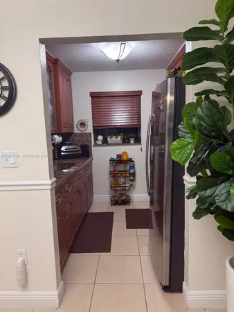 a kitchen with stainless steel appliances a refrigerator a sink a stove top oven a counter space and cabinets