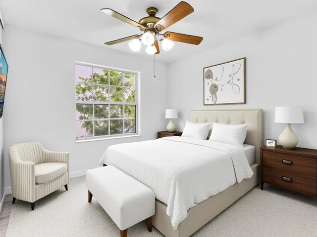 a bedroom with a bed couches and window