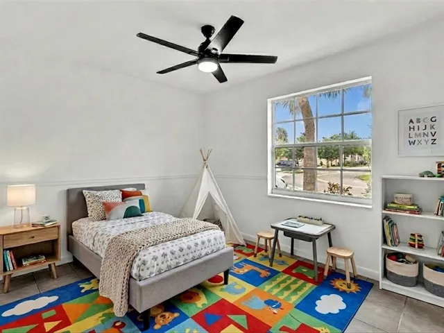a bedroom with a bed a dresser and a book shelf