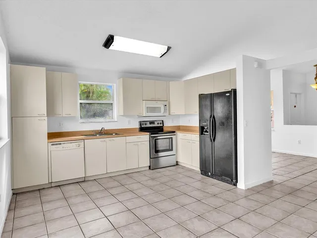 a kitchen with granite countertop white cabinets and stainless steel appliances