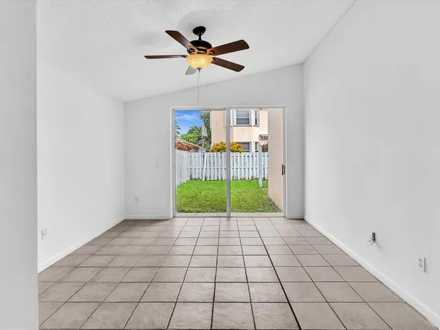 a view of a room with a ceiling fan and a rug