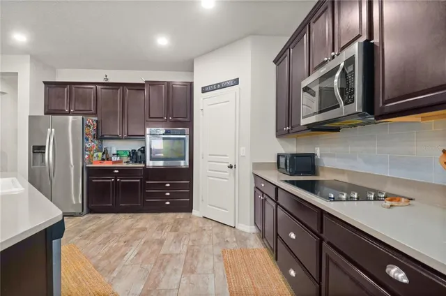 a kitchen with stainless steel appliances granite countertop a refrigerator and a stove top oven