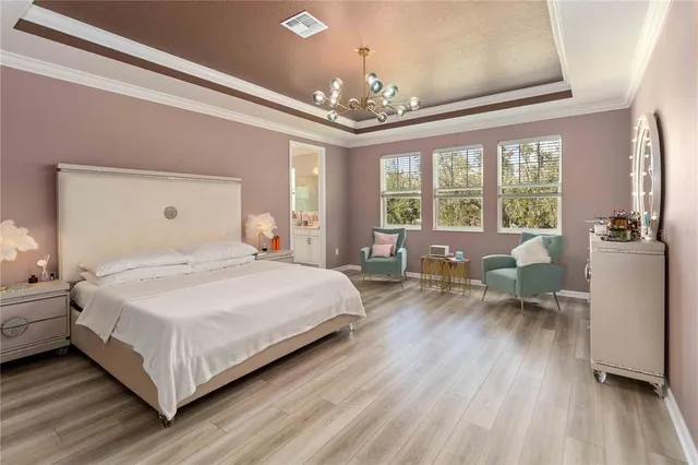 a bedroom with a bed chandelier and a window