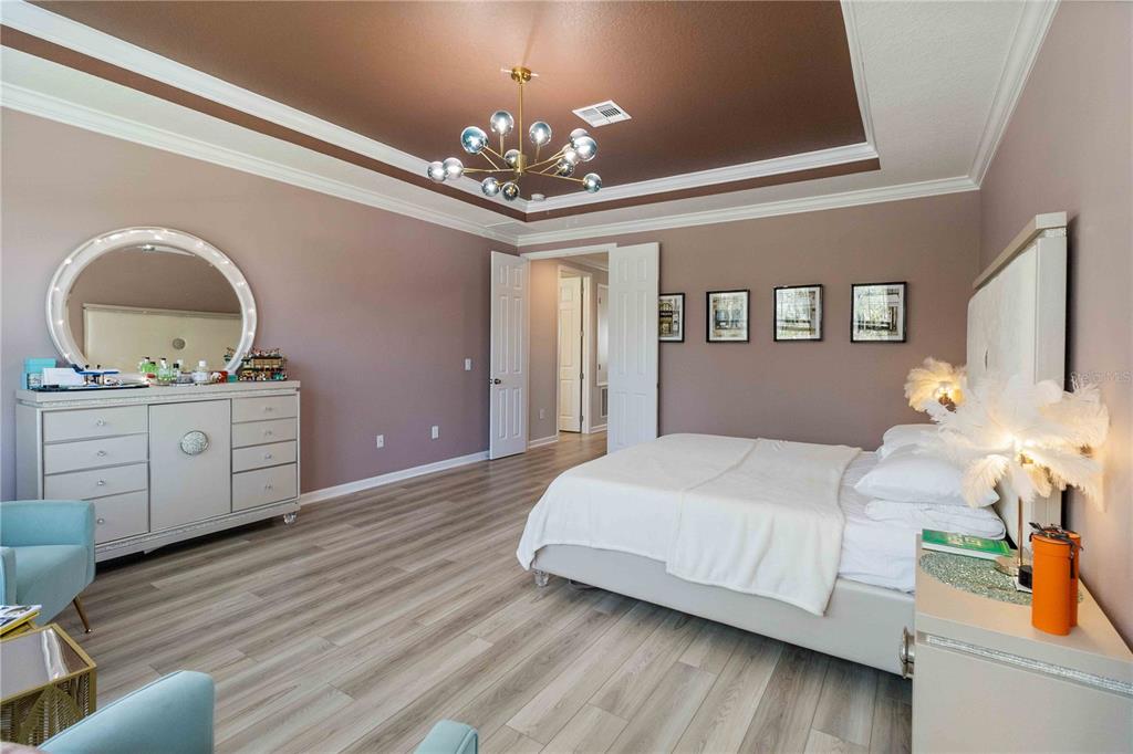 14327 Wabasso Loop Winter Garden, FL 34787 - Photo 28 of 48 a bedroom with a bed and a chandelier