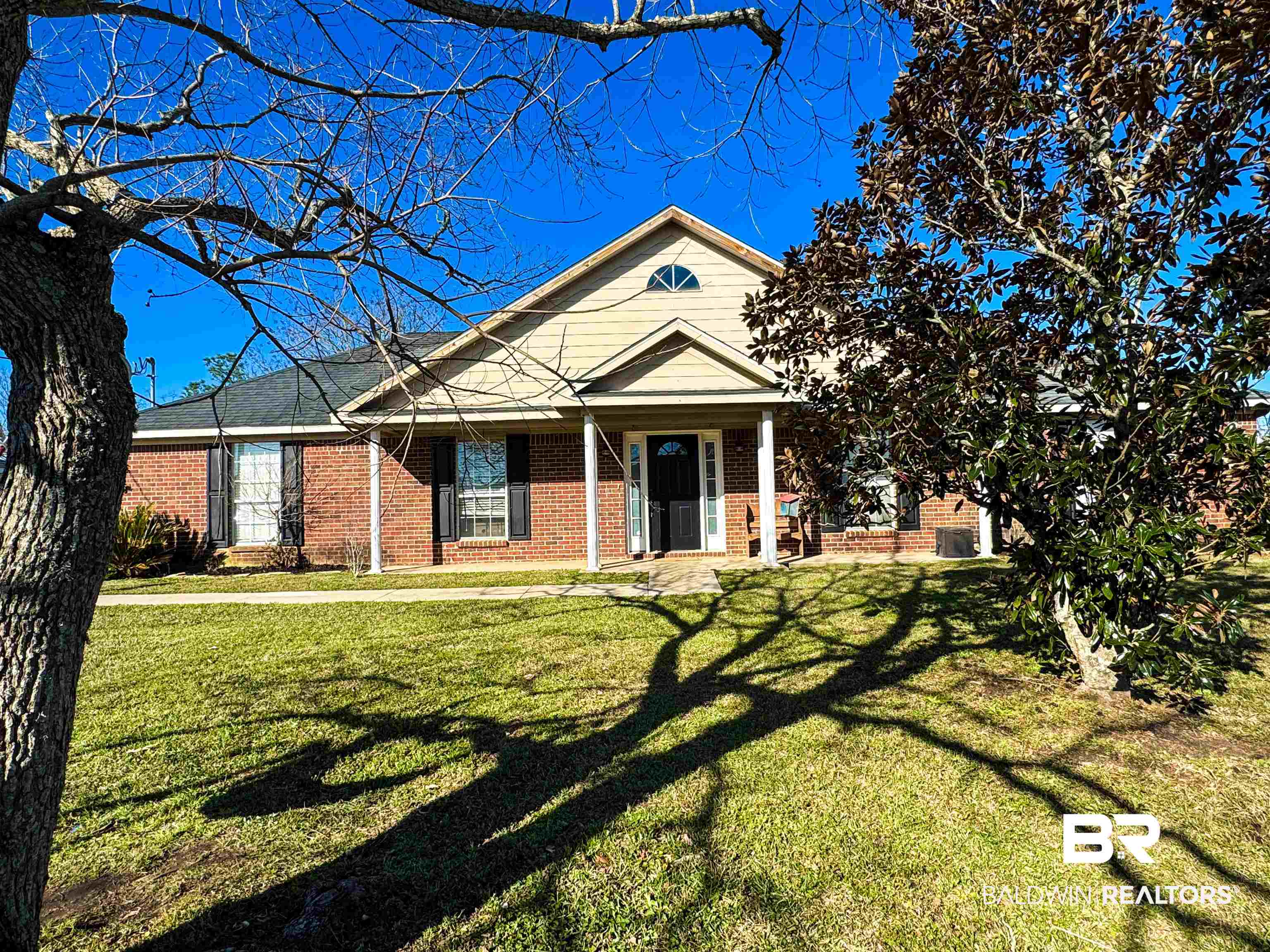 View of front of house featuring a front yard and brick siding