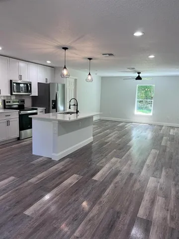 a view of kitchen with sink microwave and refrigerator
