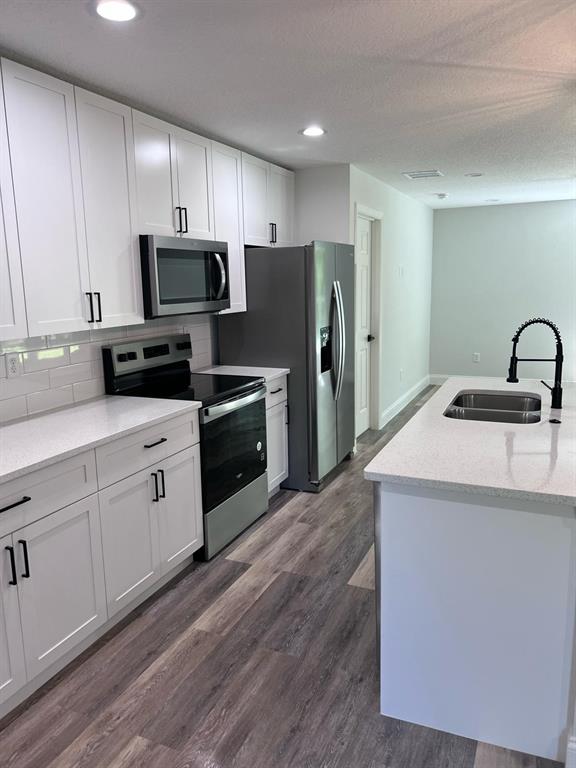 10268 North Harbor Way Citrus Springs, FL 34434 - Photo 7 of 23 a kitchen with a sink a refrigerator a microwave and cabinets