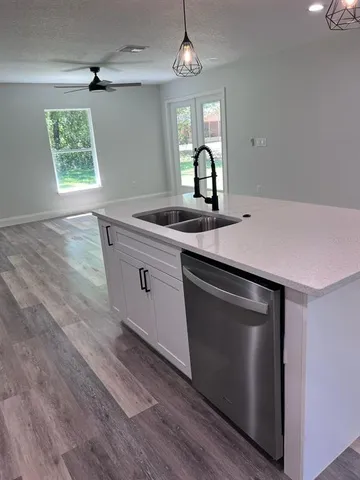 a kitchen with stainless steel appliances granite countertop a sink a microwave cabinets and wooden floor