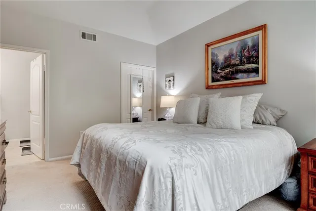 a bedroom with a bed and painting on the wall