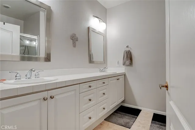 a bathroom with a double vanity sink and a mirror
