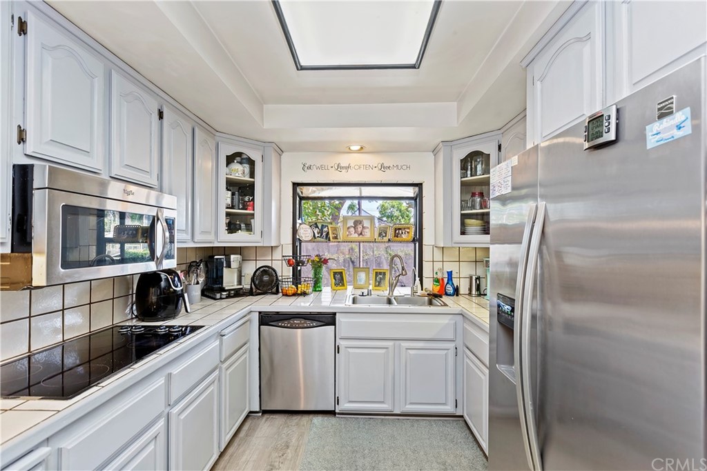 5201 Coventry Drive Riverside, CA 92506 - Photo 23 of 42 a kitchen with white cabinets and appliances