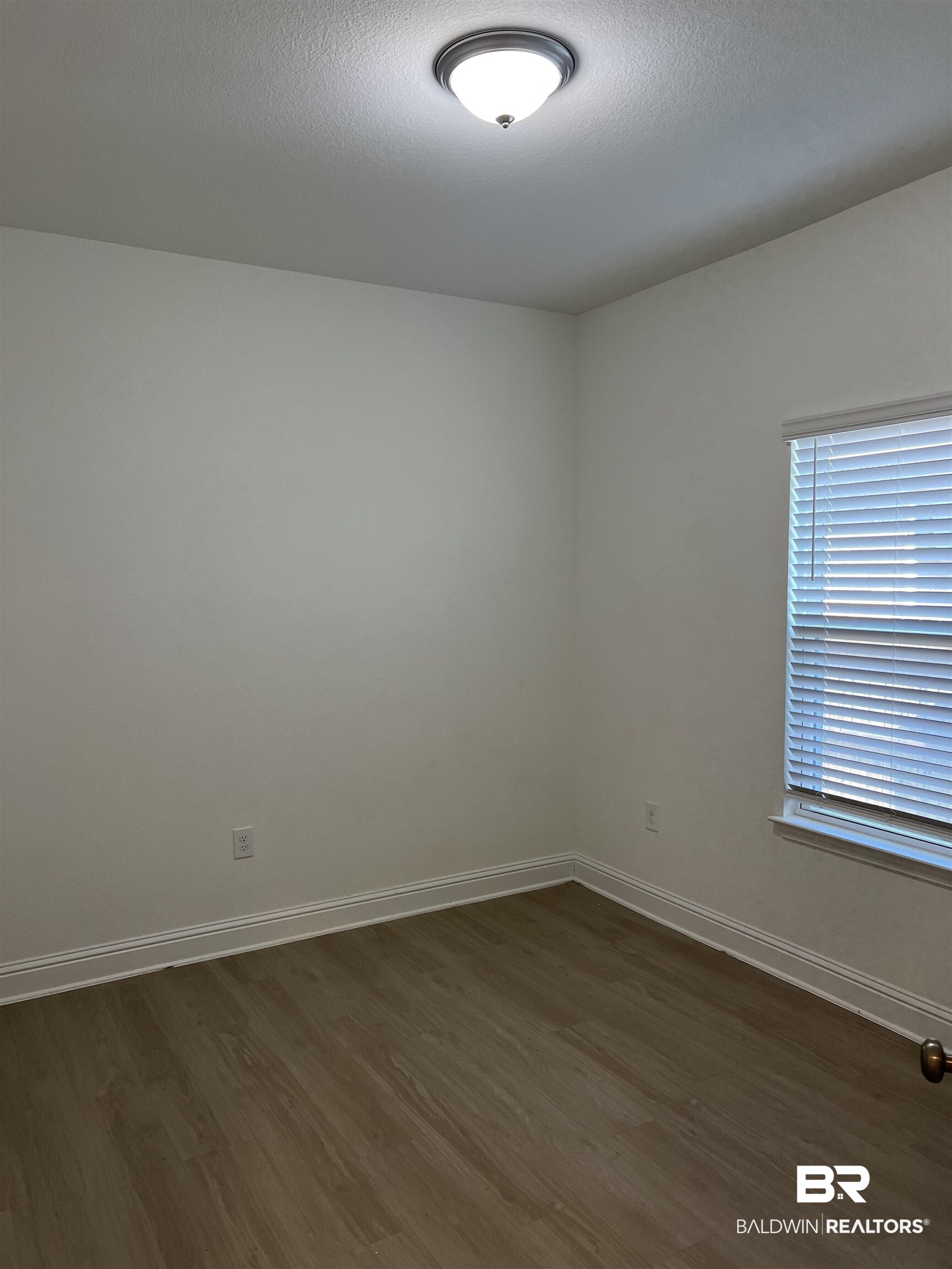8855 Calverton Street Foley, AL 36535 - Photo 21 of 76 Empty room with dark wood-type flooring and a textured ceiling