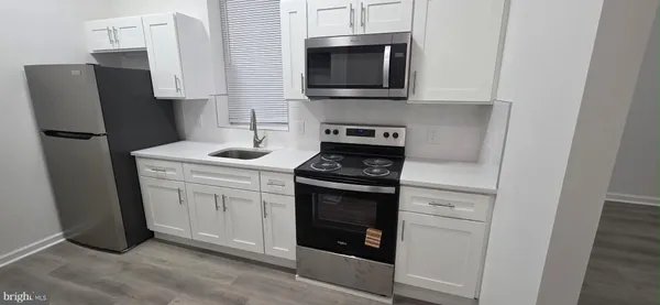 a kitchen with stainless steel appliances a refrigerator stove and microwave
