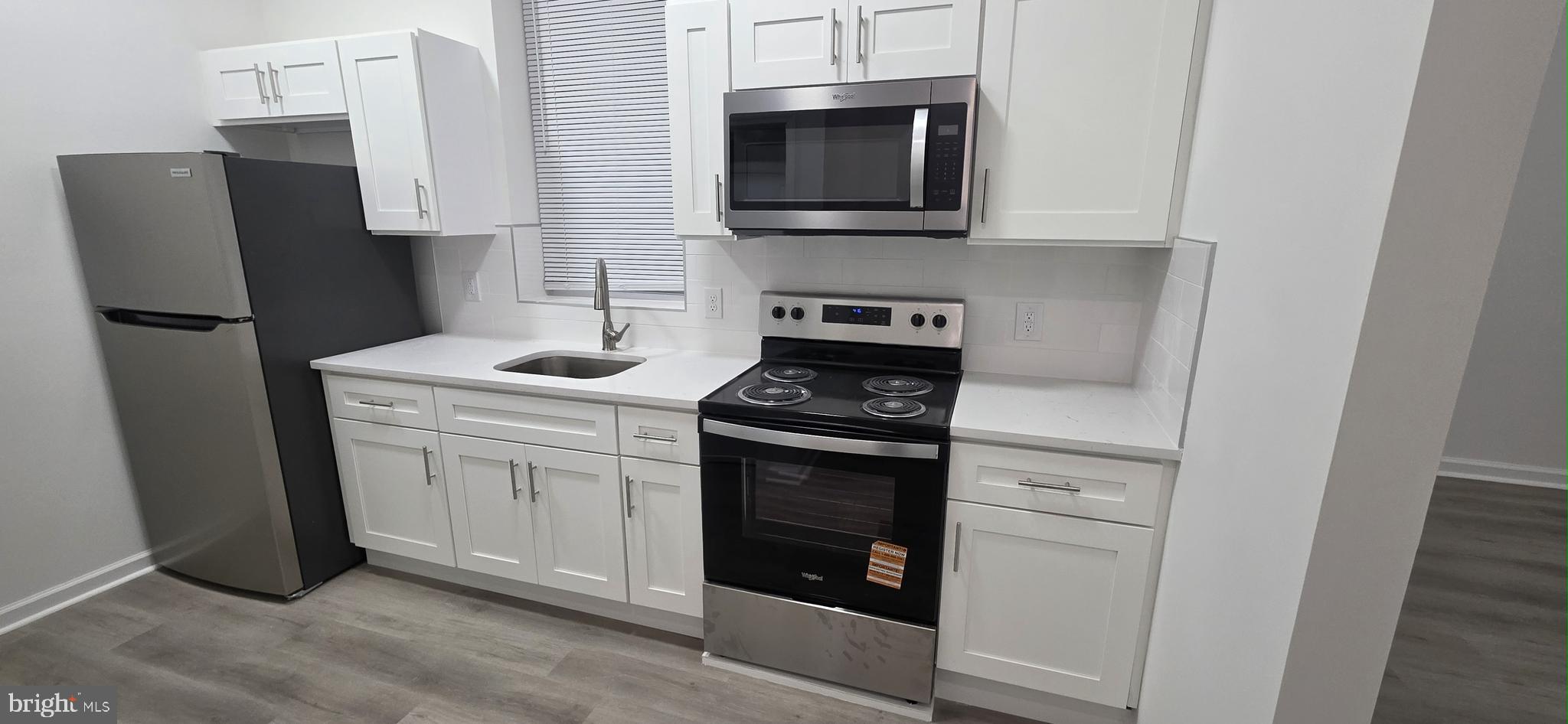 2233 North 16th Street Philadelphia, PA 19132 - Photo 2 of 27 a kitchen with stainless steel appliances a refrigerator stove and microwave