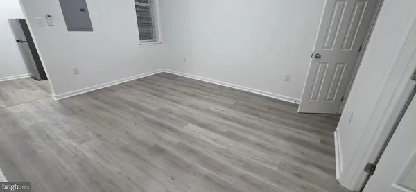 an empty room with wooden floor and entrance
