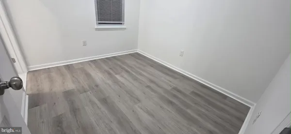 a view of a small space with wooden floor and a window
