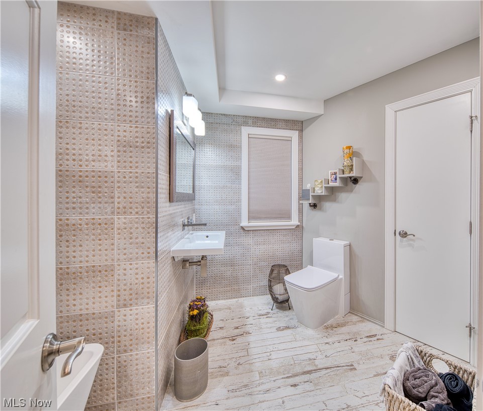 32199 Cedar Road Cleveland, OH 44124 - Photo 24 of 31 Bathroom featuring sink, tile walls, and toilet