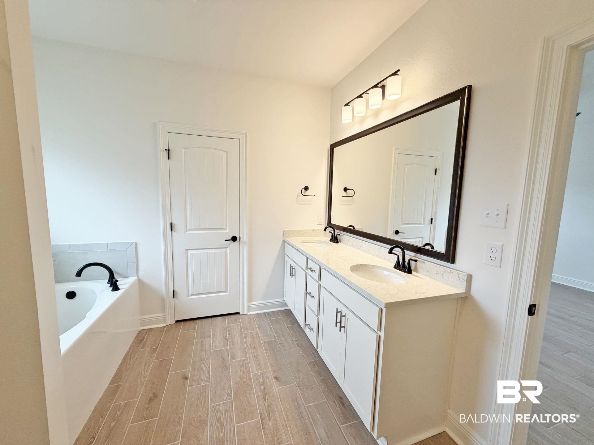 1753 Breckinridge Place Foley, AL 36535 - Photo 12 of 24 Bathroom featuring a double vanity with stone countertops, undermount sinks, and matte black fixtures