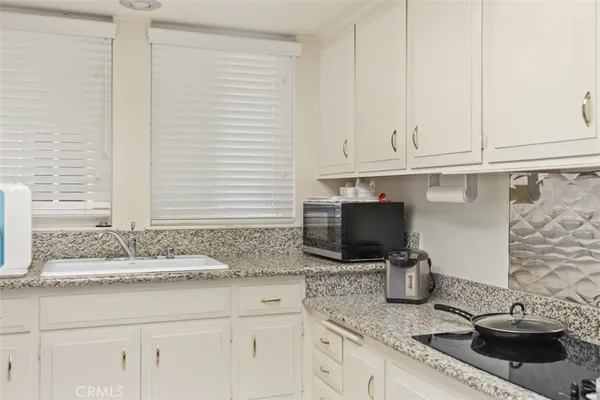 a kitchen with cabinets and chairs