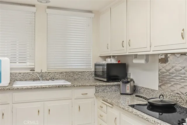 a kitchen with cabinets and chairs