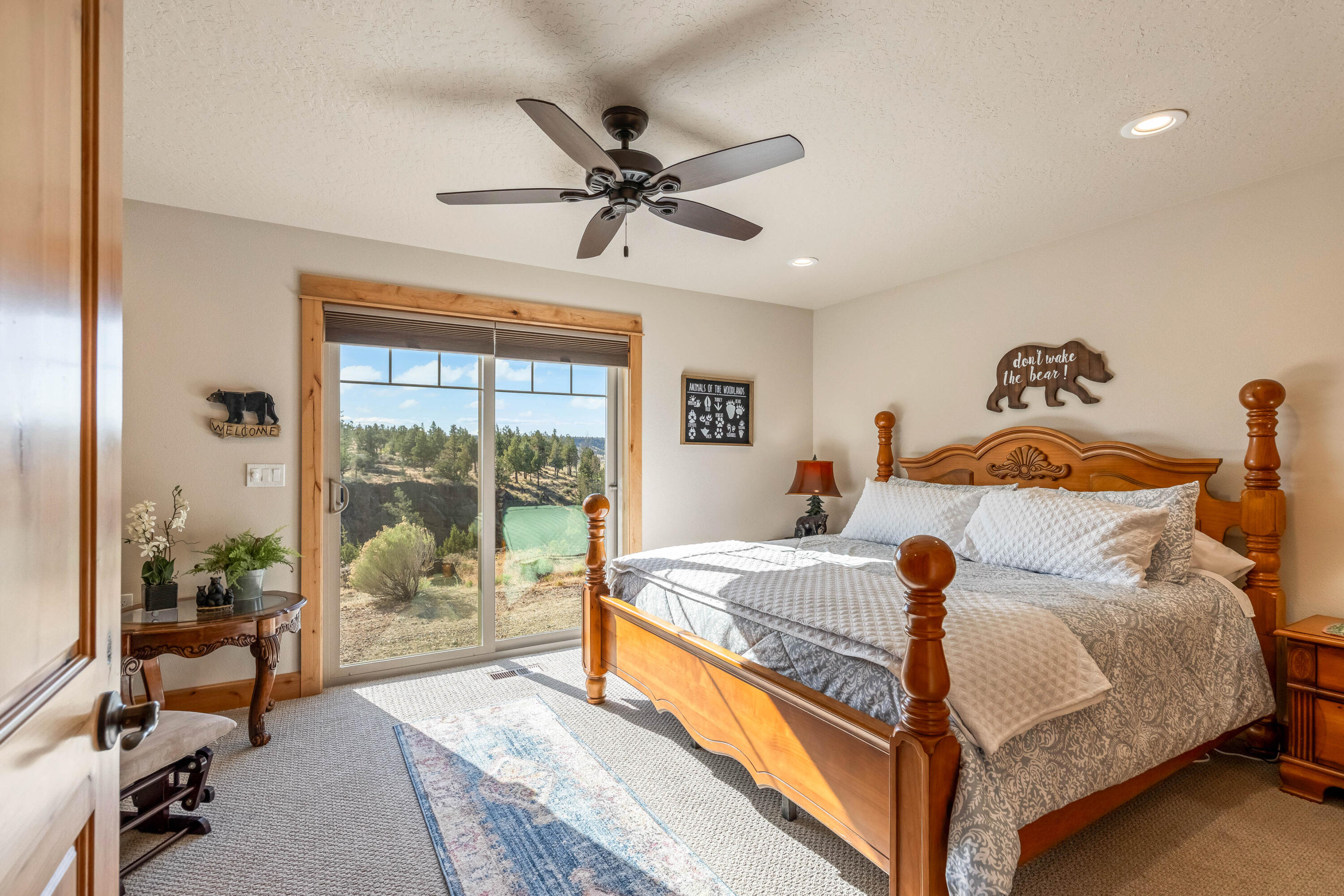 70030 Northwest Hunt Road Sisters, OR 97759 - Photo 18 of 55 a bedroom with a large bed and a chandelier
