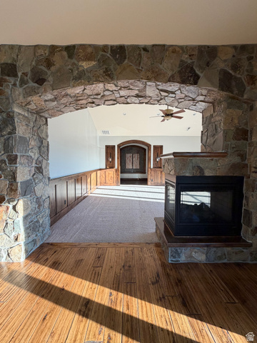 4536 North 475 East Provo, UT 84604 - Photo 38 of 65 Stone archway entry featuring a built-in fireplace with a stone hearth, wood-finish flooring, and recessed lighting