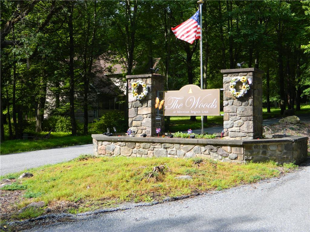 328 Pin Oak Road Stroudsburg, PA 18360 - Photo 42 of 42 Stone pillars frame the entrance to a wooded residential community, hinting at serene living.