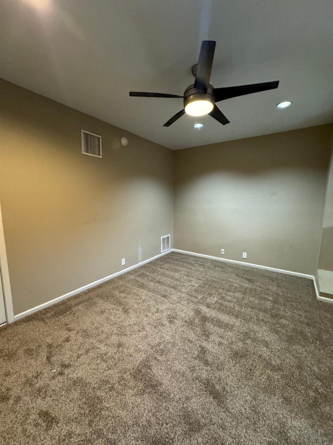 3111 30th Street Lubbock, TX 79410 - Photo 4 of 12 an empty room with a ceiling fan and carpet