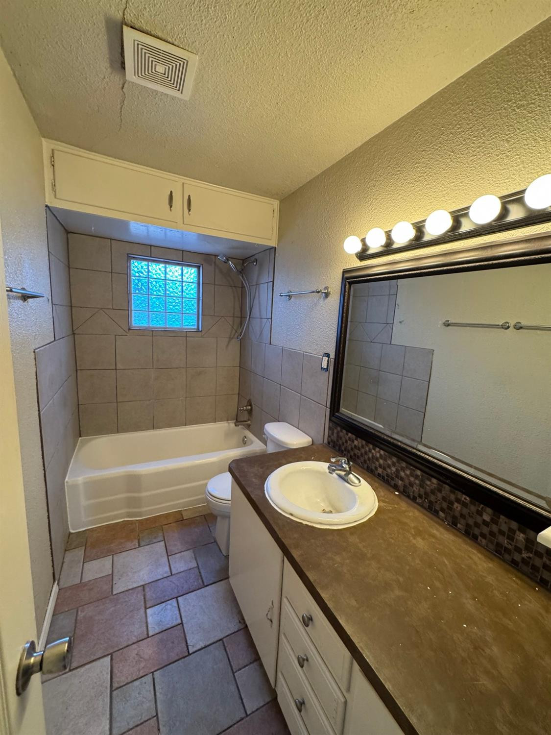 3111 30th Street Lubbock, TX 79410 - Photo 6 of 12 a bathroom with a granite countertop sink toilet and a bathtub