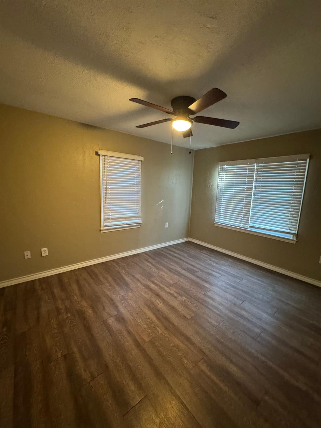 3111 30th Street Lubbock, TX 79410 - Photo 7 of 12 an empty room with wooden floor and windows