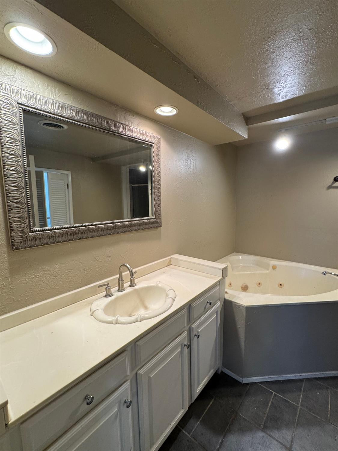 3111 30th Street Lubbock, TX 79410 - Photo 9 of 12 a bathroom with a sink a vanity and a mirror