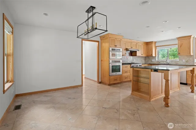 a view of an empty room with wooden floor fireplace and a window