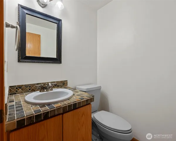 an empty room with chandelier fan and windows