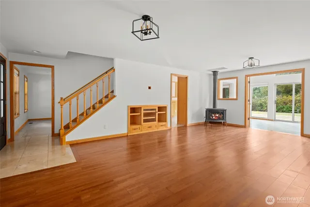 a view of an empty room with window and wooden floor