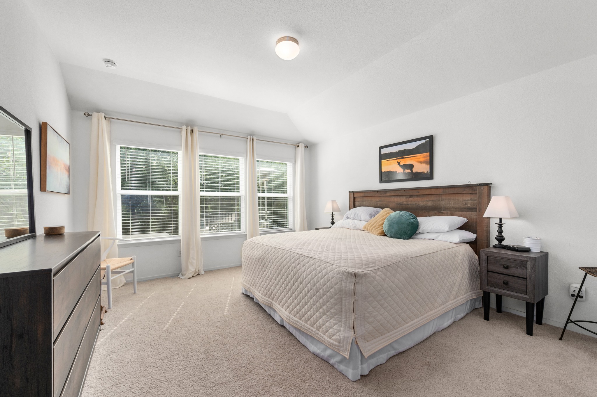 21006 Santa Rosa Avenue Lago Vista, TX 78645 - Photo 10 of 26 Plenty of natural illumination fills this restful bedroom, featuring an elegant wooden bed frame and plush carpeting.