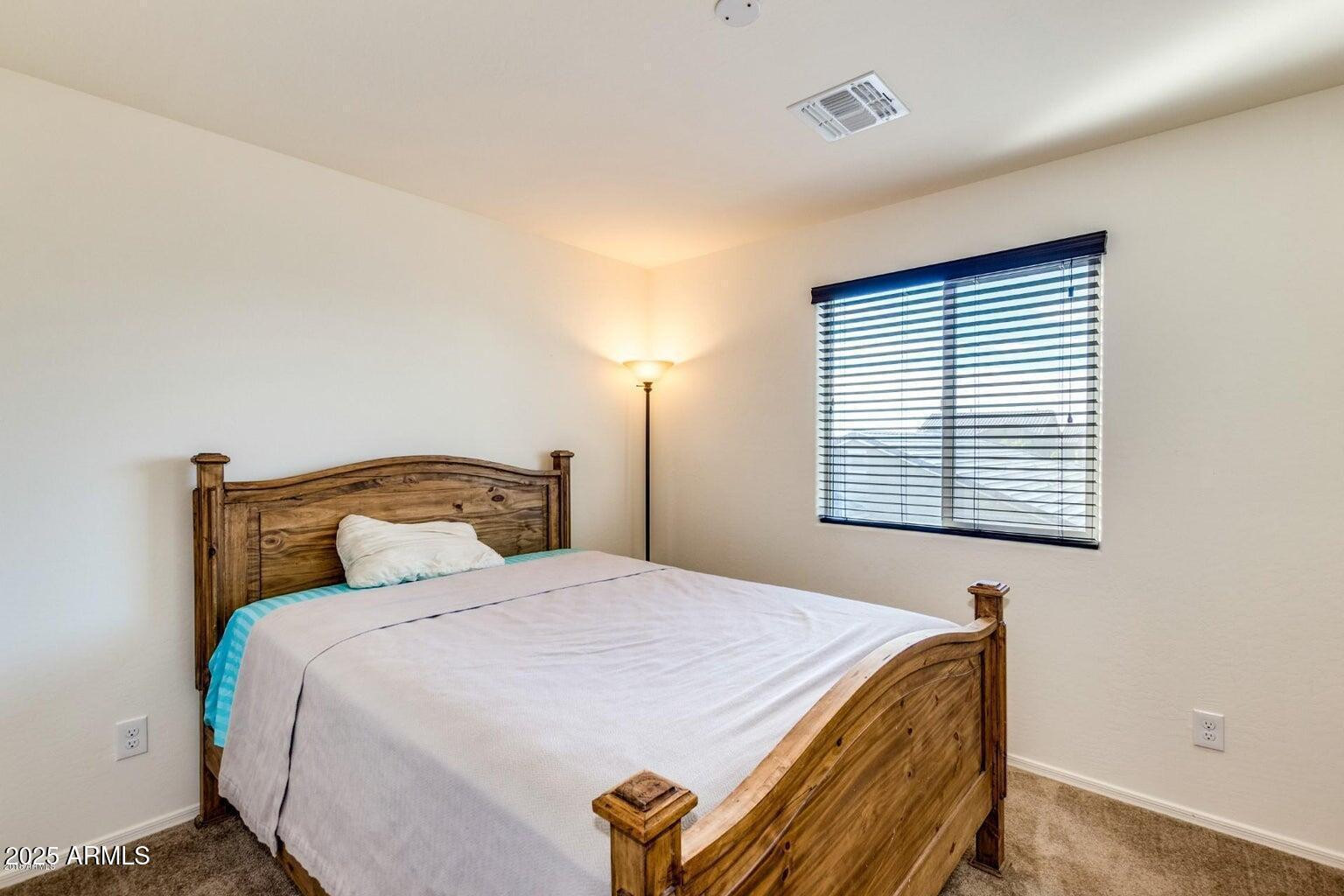 12057 West Rowel Road Peoria, AZ 85383 - Photo 11 of 20 a bedroom with a bed and a window