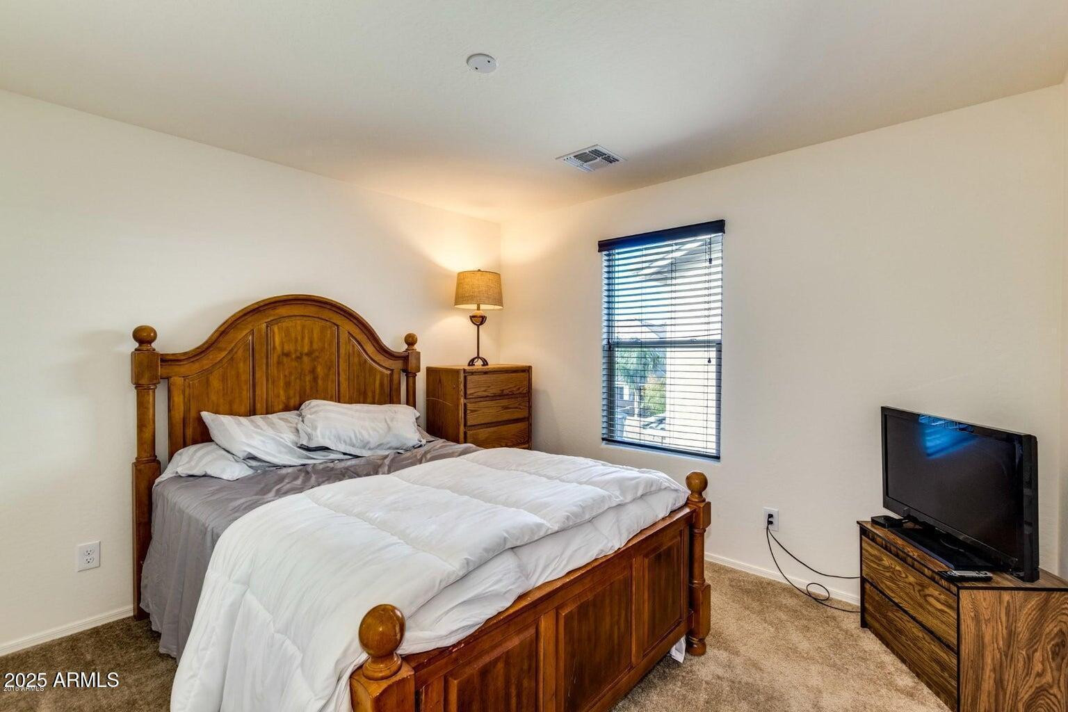 12057 West Rowel Road Peoria, AZ 85383 - Photo 12 of 20 a bedroom with a bed and a flat screen tv