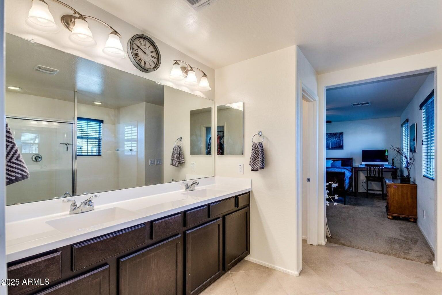12057 West Rowel Road Peoria, AZ 85383 - Photo 18 of 20 a en suite bathroom with a double vanity sink and a mirror