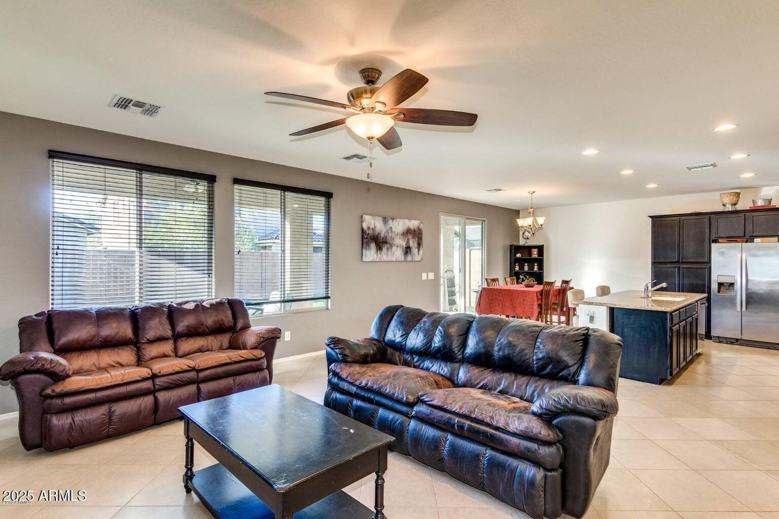 12057 West Rowel Road Peoria, AZ 85383 - Photo 2 of 20 a living room with furniture ceiling fan and a large window